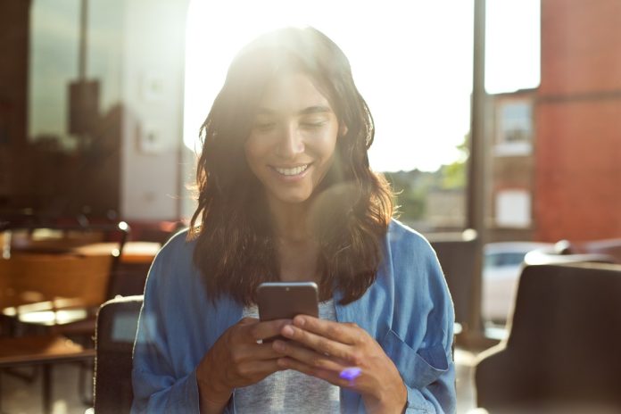 Young woman using mobile phone in coffee shop